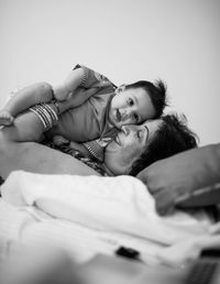 Side view of grandmother with son lying on bed