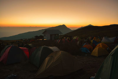 View of tents on mountain during sunset