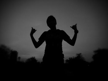 Low angle view of silhouette man jumping against sky