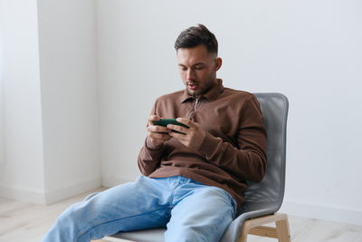 Young man sitting on sofa at home