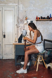 Craftsperson sewing leather at workshop