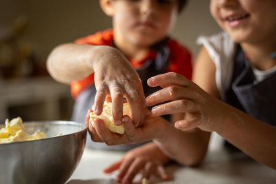 Close view of children's hands preparing food at home