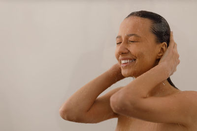 Portrait of shirtless young woman in bathroom