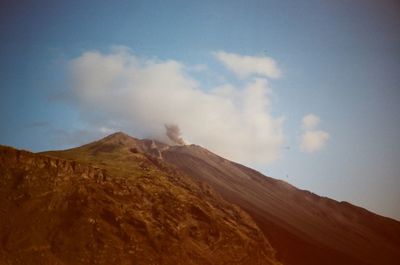 Scenic view of mountains against cloudy sky