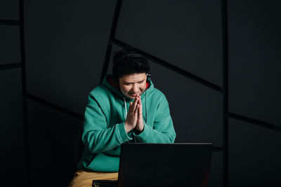 Young man using mobile phone while sitting on table