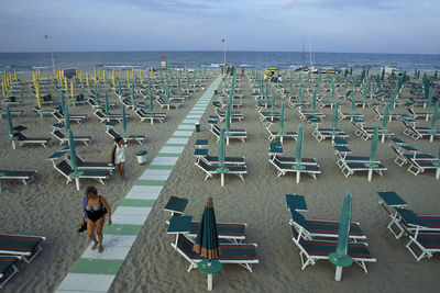 Chairs on beach against sky