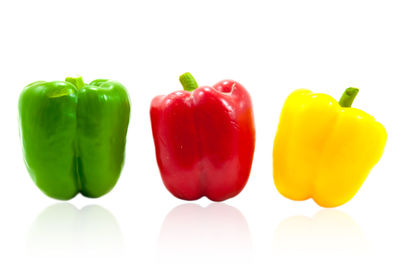 Close-up of multi colored bell peppers against white background