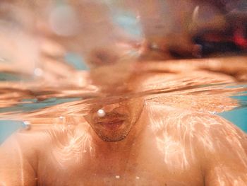 Low section of man swimming in sea