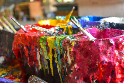 Close-up of messy paint cans in workshop