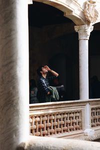 Low angle view of young man standing in historic building