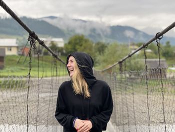 Smiling woman looking away on suspension bridge