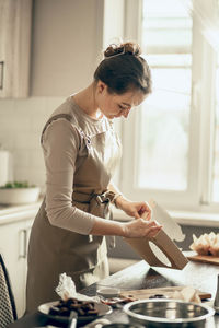 Female bakery owner packs boxes for customers order in birthday, birthday package. food delivery