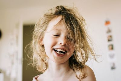 Candid portrait of young girl laughing after waking up in the morning