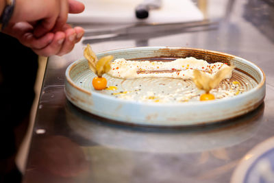 Cropped hand of person preparing food on table