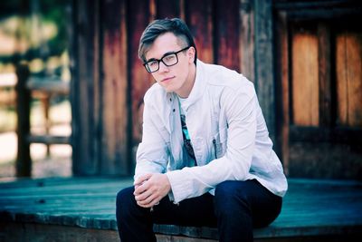 Portrait of young man sitting on floorboard