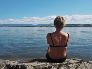 Rear view of woman looking at sea against sky