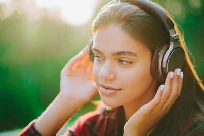 Portrait of smiling young woman using mobile phone outdoors