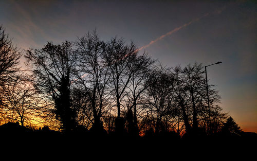 Low angle view of silhouette trees against sky at sunset