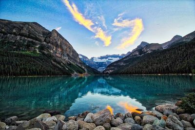 Scenic view of lake by mountains against sky