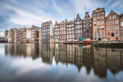 Reflection of buildings in canal against sky