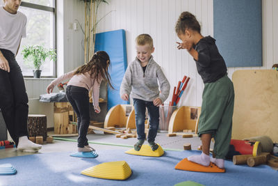 Happy male and female students playing in kindergarten