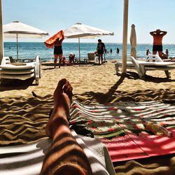 Low section of people relaxing on beach