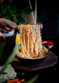 Cropped hand of person preparing food on table