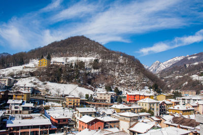 Houses in town against cloudy sky