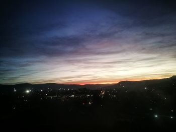 High angle view of illuminated cityscape against sky at sunset