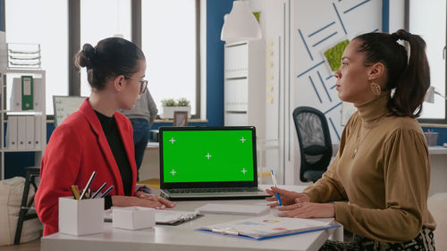 Businesswomen looking at computer at office