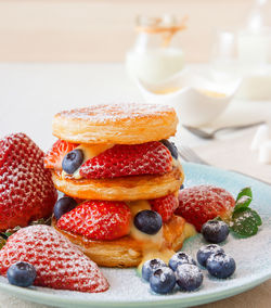 Mille feuille, high angle view of french dessert on table with summer berry fruits and lemon curd.