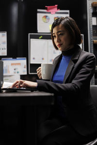 Portrait of young businesswoman using laptop at office