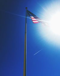 Low angle view of american flag against blue sky