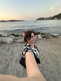 Low section of woman standing at beach against sky