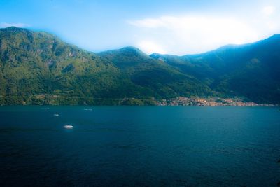 Scenic view of sea and mountains against sky