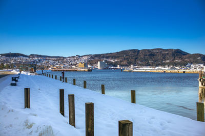 Scenic view of frozen lake against clear blue sky