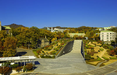 High angle view of buildings against clear blue sky