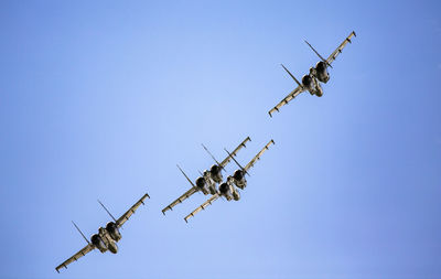 Low angle view of airplane flying against clear blue sky
