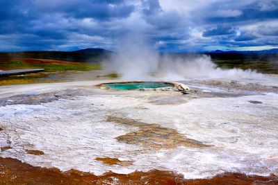 Geyser against cloudy sky