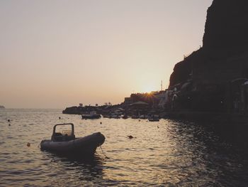 Boats in calm sea at sunset