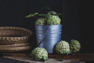 Custard apples in bucket on wooden table