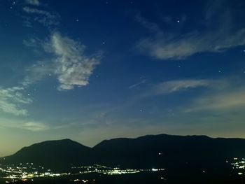 Illuminated city against sky at night