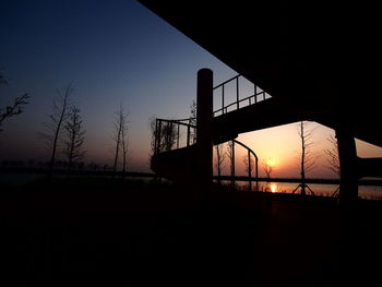 Silhouette bridge against clear sky during sunset