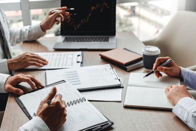 Midsection of business colleagues working at desk in office