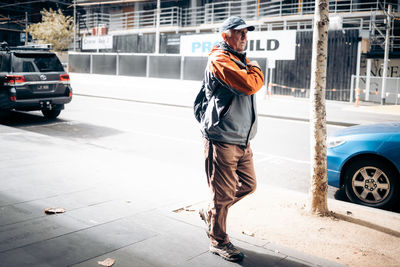 Rear view of man with umbrella on street
