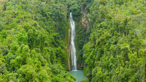 Aerial view of mantayupan waterfalls in a mountain gorge in the tropical jungle, philippines, cebu. 