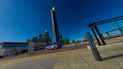 Street amidst buildings against clear blue sky