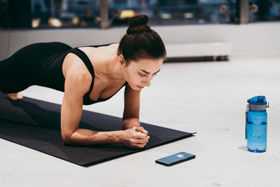 Side view of woman planking at gym