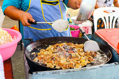 Midsection of man preparing food at market