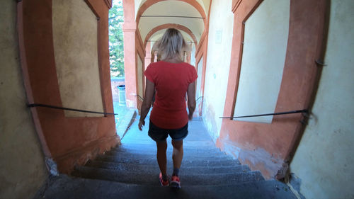 Rear view of woman walking on staircase in building